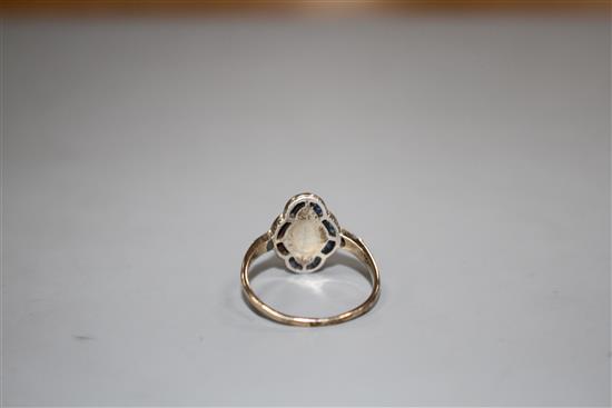 A mid 20th century yellow metal (stamped 9ct?, blue and white paste set quatrefoil shaped ring, size P, gross 2.6 grams.